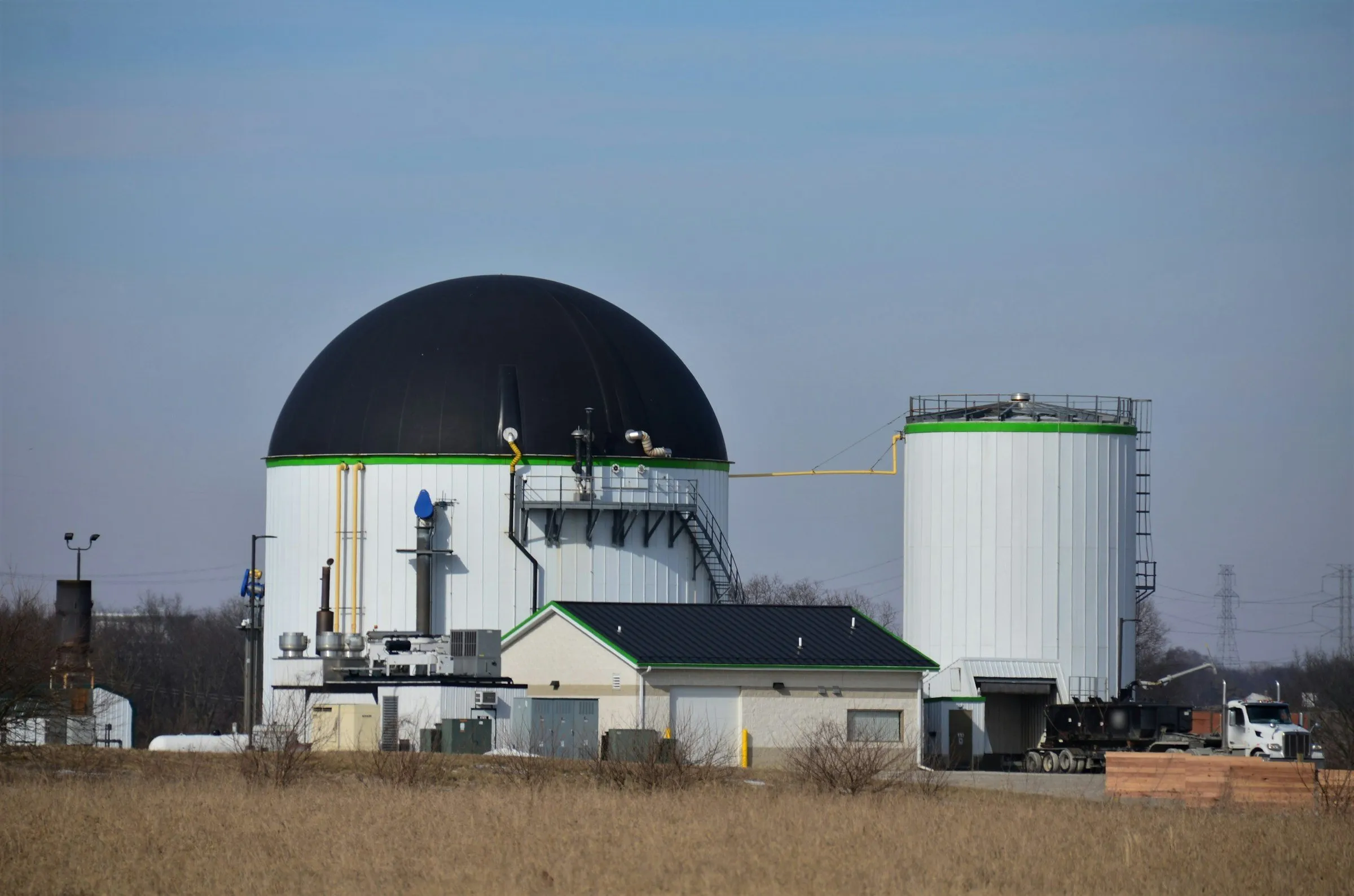 A biogas digester with a domed gas holder, gas piping and a storage tank
