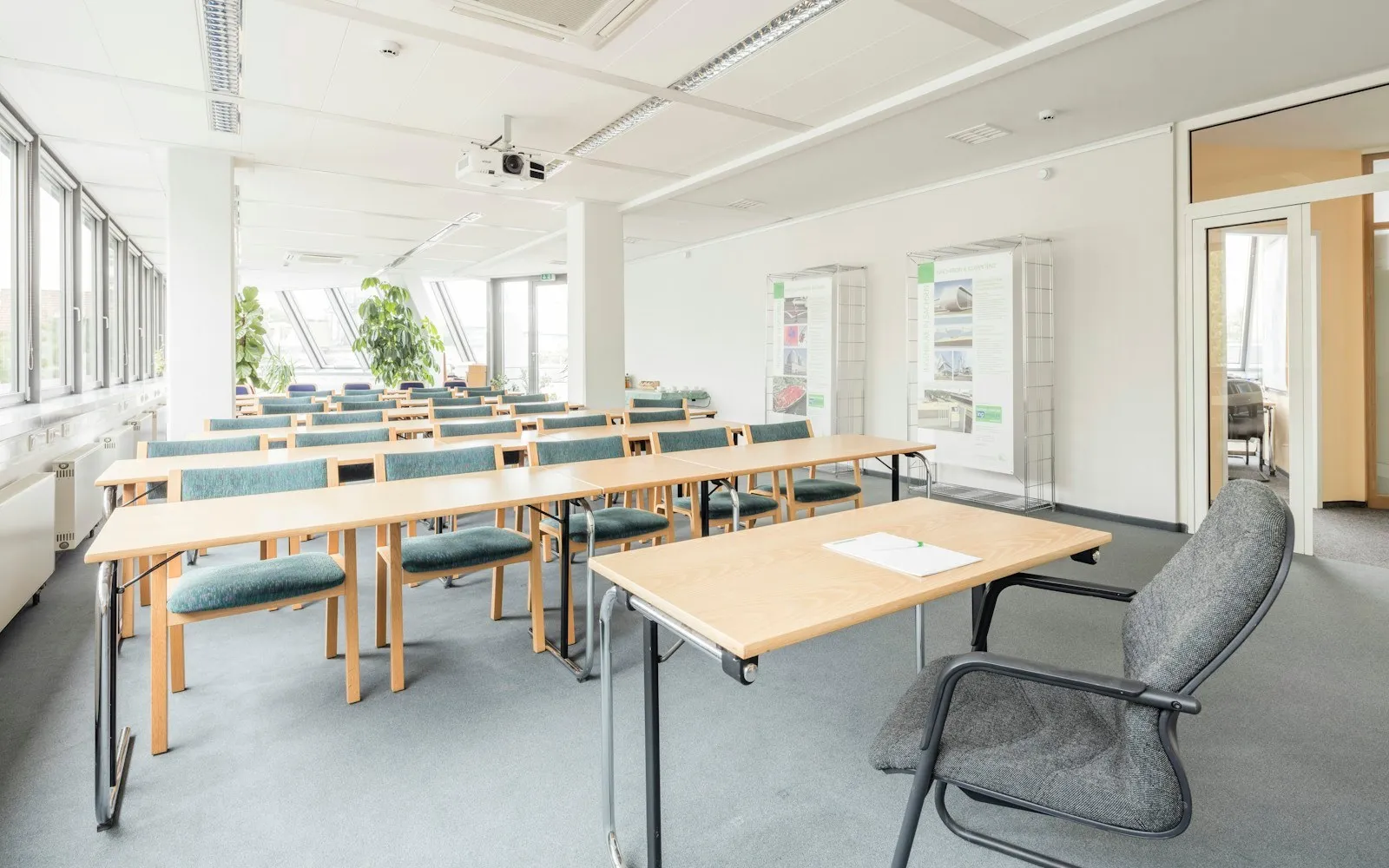 A bright classroom with tables and chairs by the windows