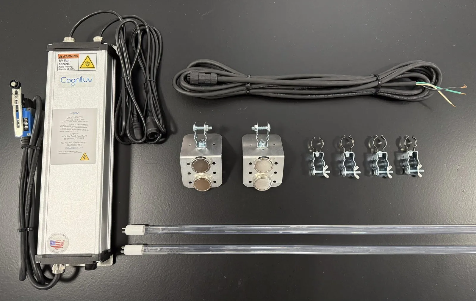 A Cognituv Grid kit laid out: the Cognituv power supply, two UV-C lamps, magnetic lamp mounts, clips and cable
