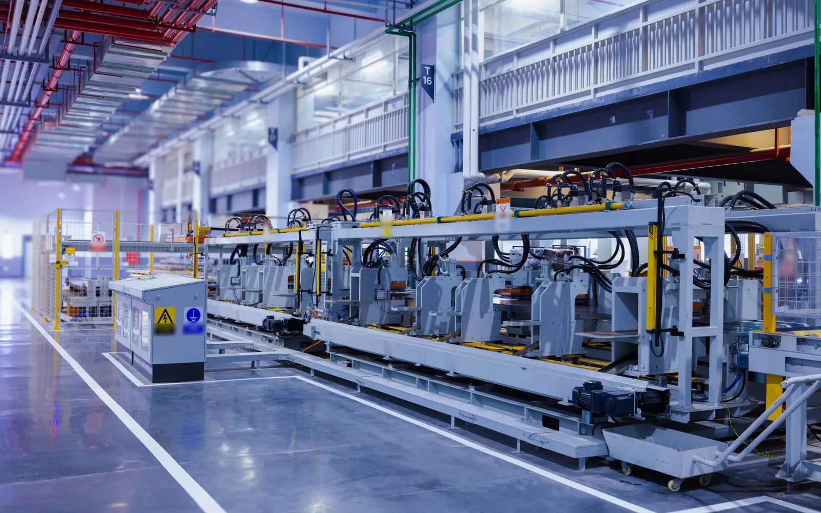 An automated production line running the length of a bright factory floor