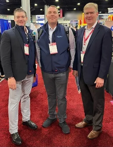 Three members of the Cognituv team standing together at a trade show
